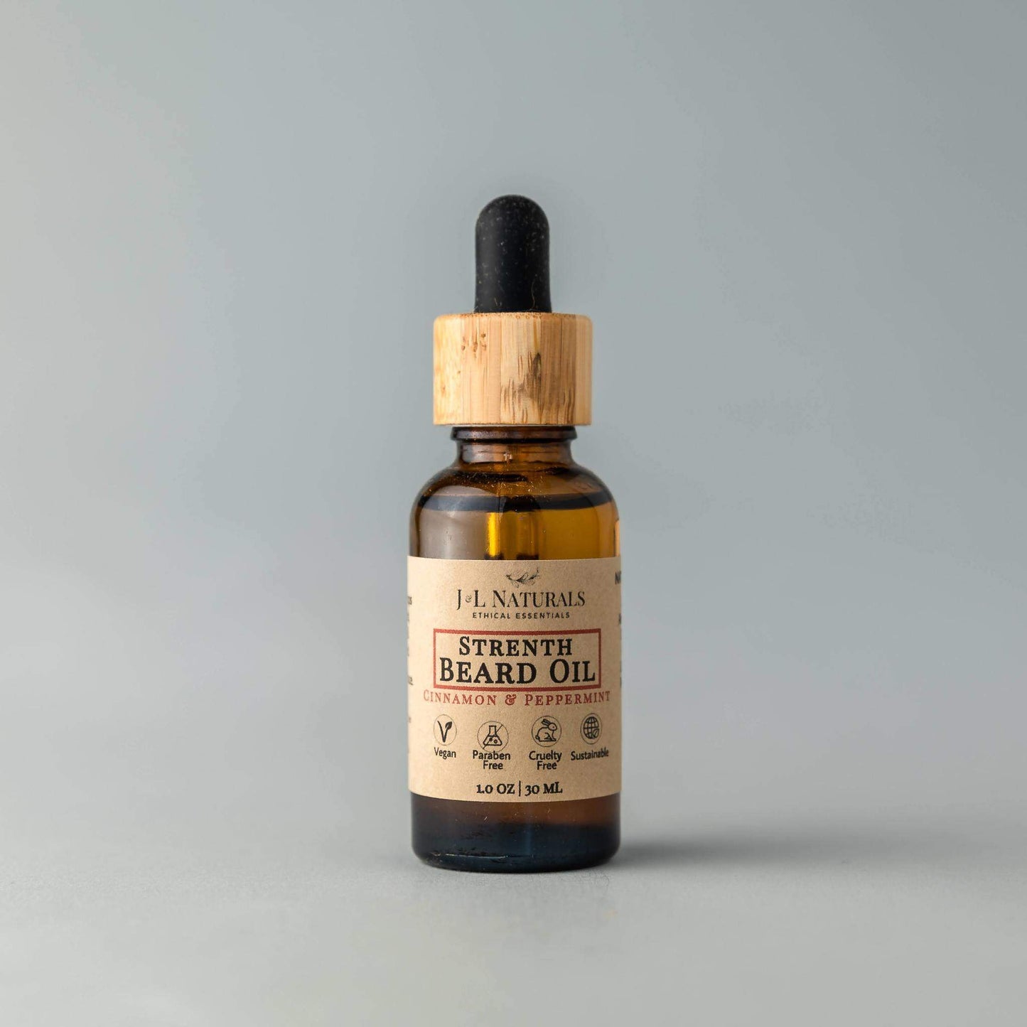 J&L Naturals Strength Beard Oil in Cinnamon & Peppermint scent, displayed upright with bamboo dropper top on neutral background.