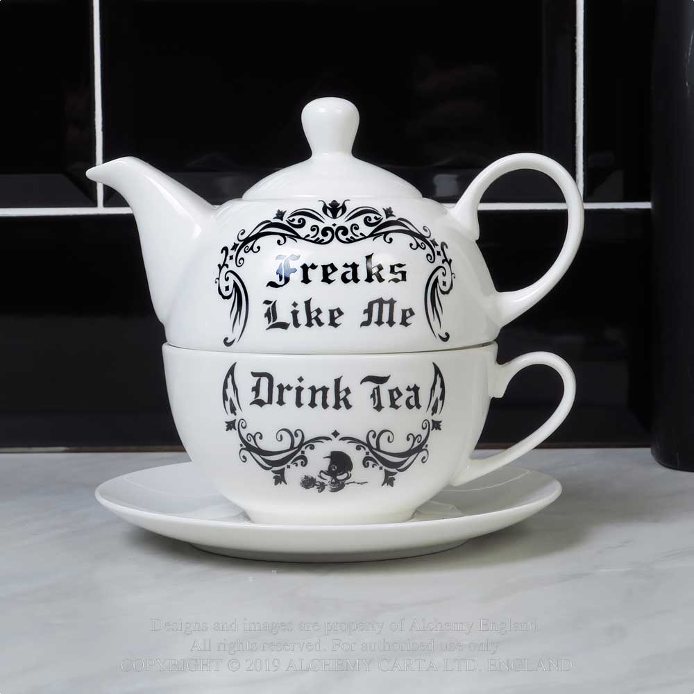 Stacked white bone china tea set with black gothic script that reads “Freaks Like Me Drink Tea,” including teapot, teacup, and saucer.