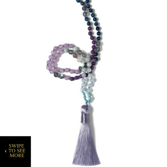 Mystic Mala necklace handcrafted with high-grade Kyanite Mystic, Aura Quartz, Sugilite, and Amazonite beads, finished with a lavender silk tassel—cleansed under the full moon for energetic alignment and spiritual clarity.